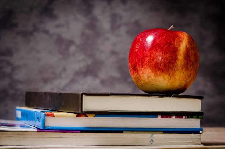 close up of apple on top of books